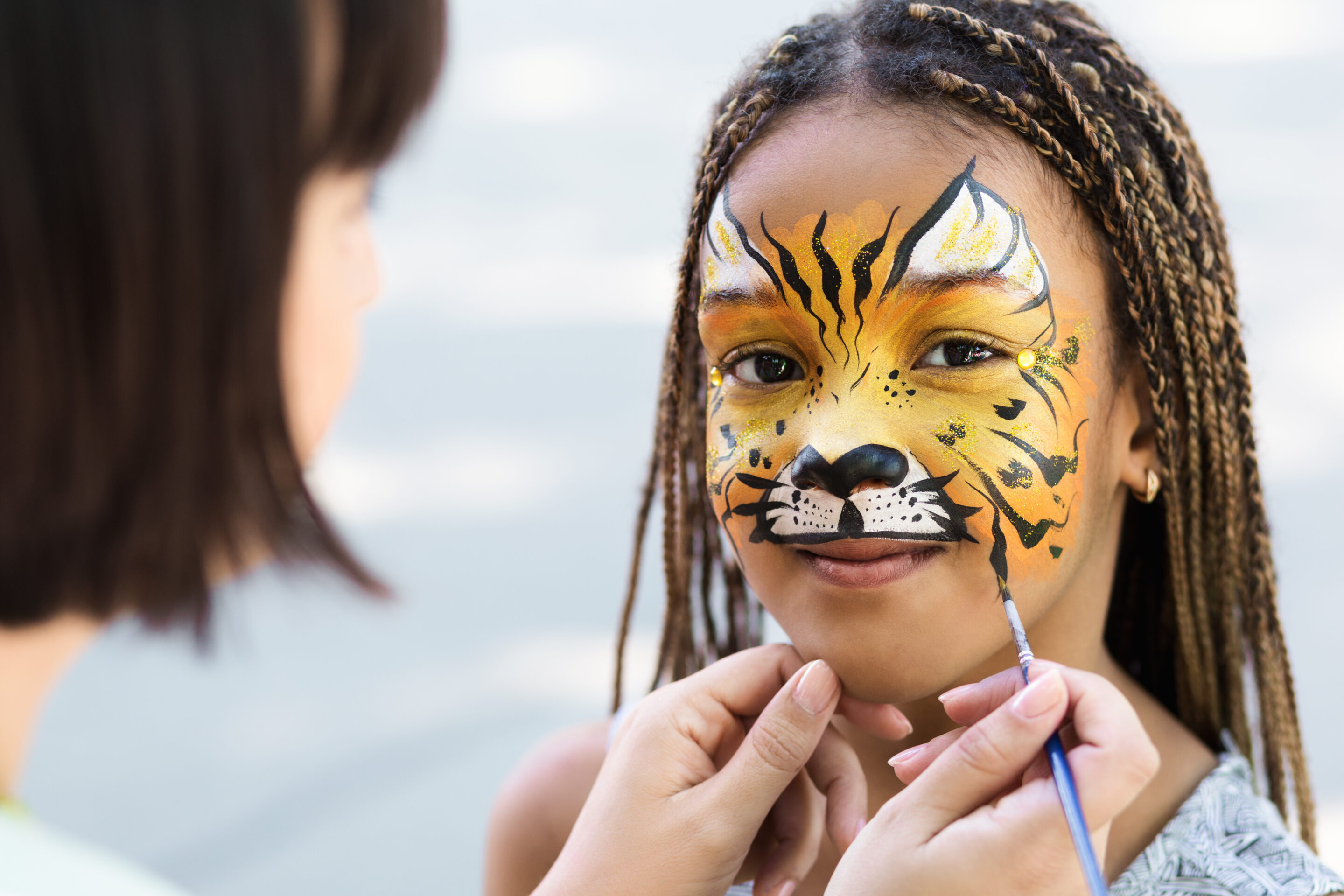 Little girl getting her face painted by face painting artist. taller de pintacaras